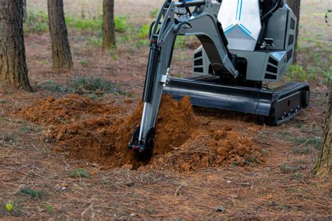 Mini excavator digging ditch and installing garage drain